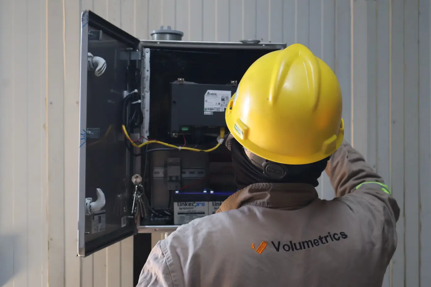 Técnico de Volumetrics con casco revisando el gabinete del sistema de medición